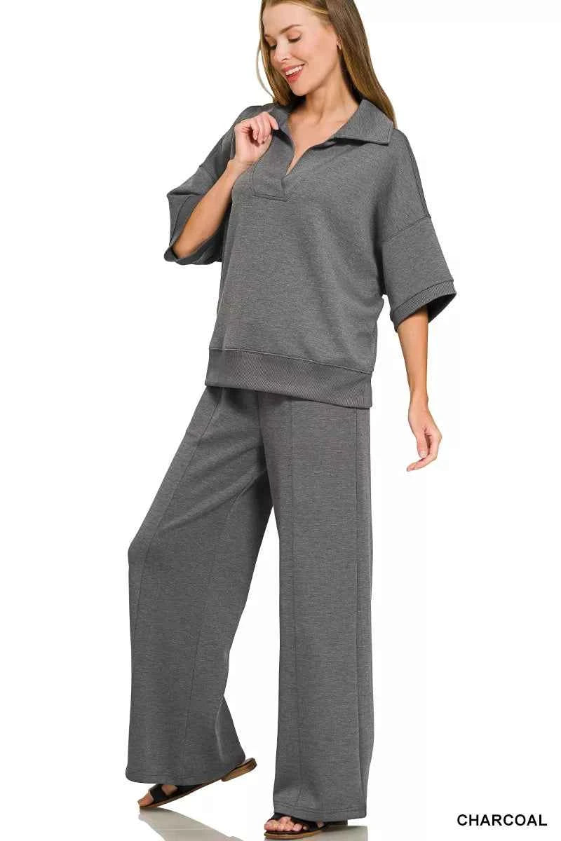 Woman wearing a Zenana charcoal scuba knit two-piece set featuring a collared short-sleeve pullover top and matching wide-leg pants with pockets. Front View