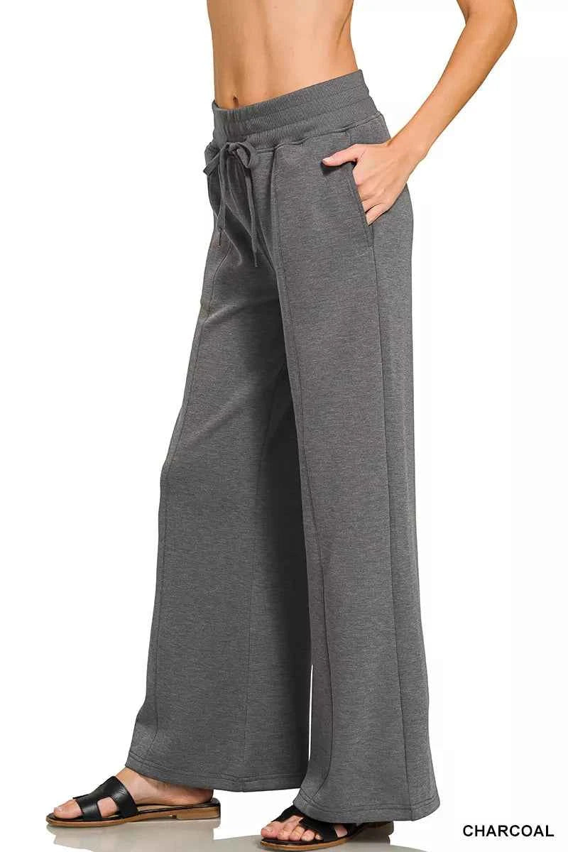 Woman wearing a Zenana charcoal scuba knit two-piece set featuring a collared short-sleeve pullover top and matching wide-leg pants with pockets.