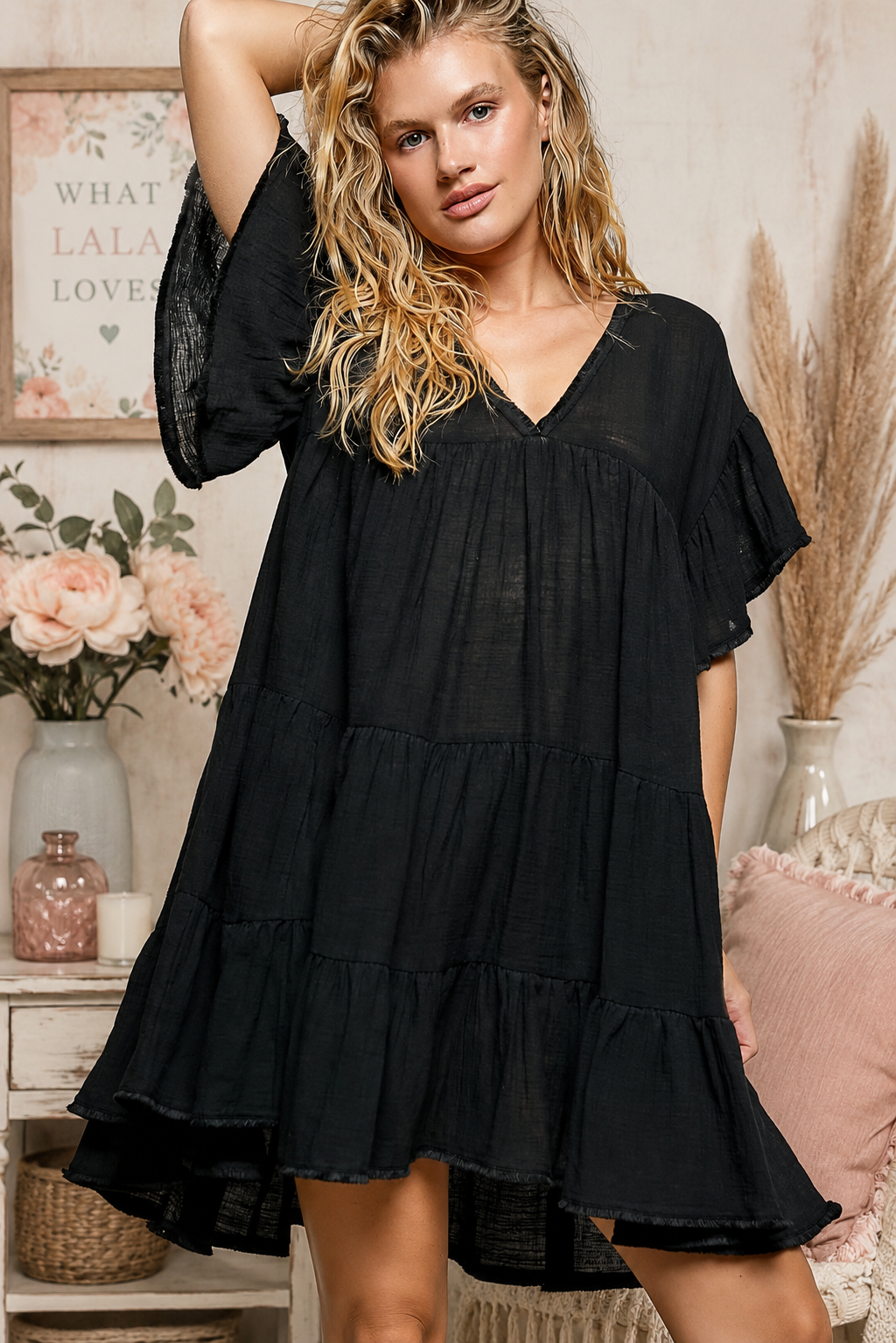 Woman wearing a black POL cotton dress featuring a V-neckline, tiered ruffle design, and relaxed flowy silhouette.
 Front View