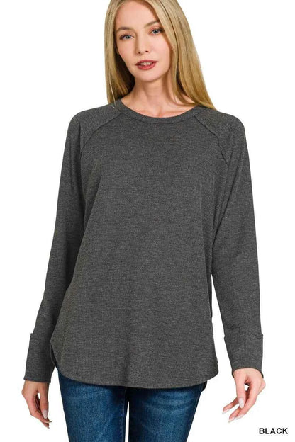 Woman wearing a black baby waffle knit long sleeve top by Zenana featuring raglan sleeves, a crew neckline, and a relaxed fit. Front View 2