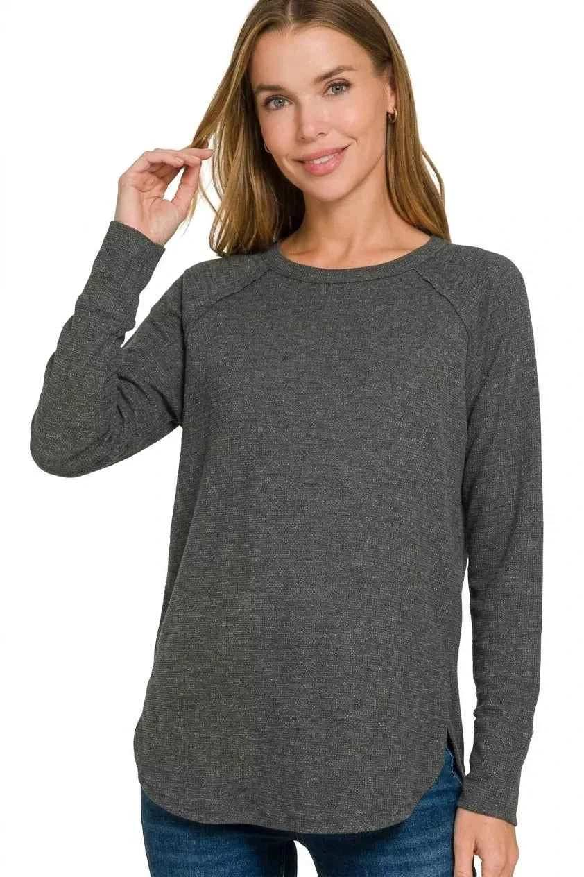 Woman wearing a black baby waffle knit long sleeve top by Zenana featuring raglan sleeves, a crew neckline, and a relaxed fit. Front View 3