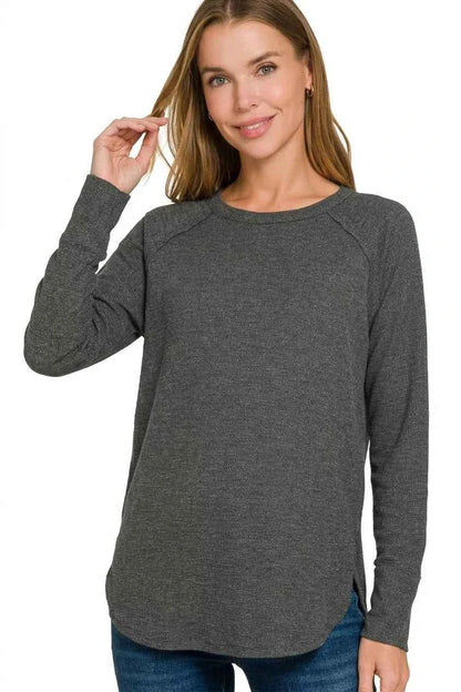 Woman wearing a black baby waffle knit long sleeve top by Zenana featuring raglan sleeves, a crew neckline, and a relaxed fit. Front View 3
