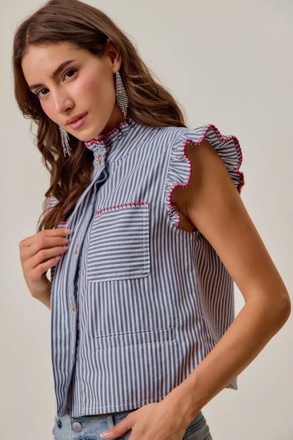 Woman wearing a blue and white striped sleeveless twill vest by SO ME featuring red whipstitch trim, ruffled collar, hidden button front and front pockets. Side View 2