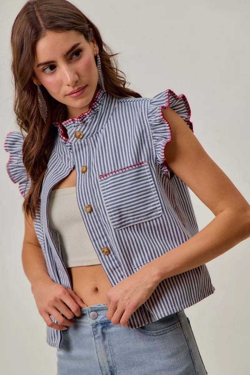 Woman wearing a blue and white striped sleeveless twill vest by SO ME featuring red whipstitch trim, ruffled collar, hidden button front and front pockets. Front view 4