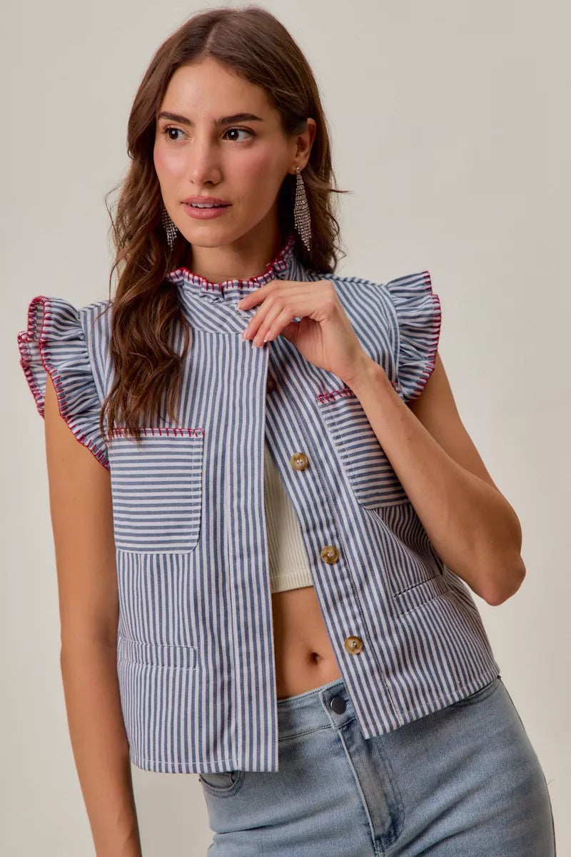 Woman wearing a blue and white striped sleeveless twill vest by SO ME featuring red whipstitch trim, ruffled collar, hidden button front and front pockets. Front view 5