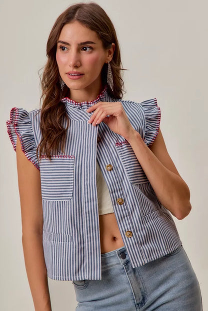 Woman wearing a blue and white striped sleeveless twill vest by SO ME featuring red whipstitch trim, ruffled collar, hidden button front and front pockets. Front view 5