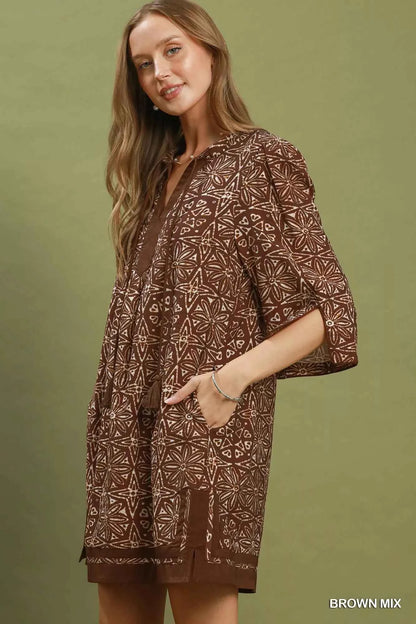 Woman wearing a brown geometric print tunic dress with a V-neckline, tassel ties, and three-quarter slit sleeves by Umgee. Side View
