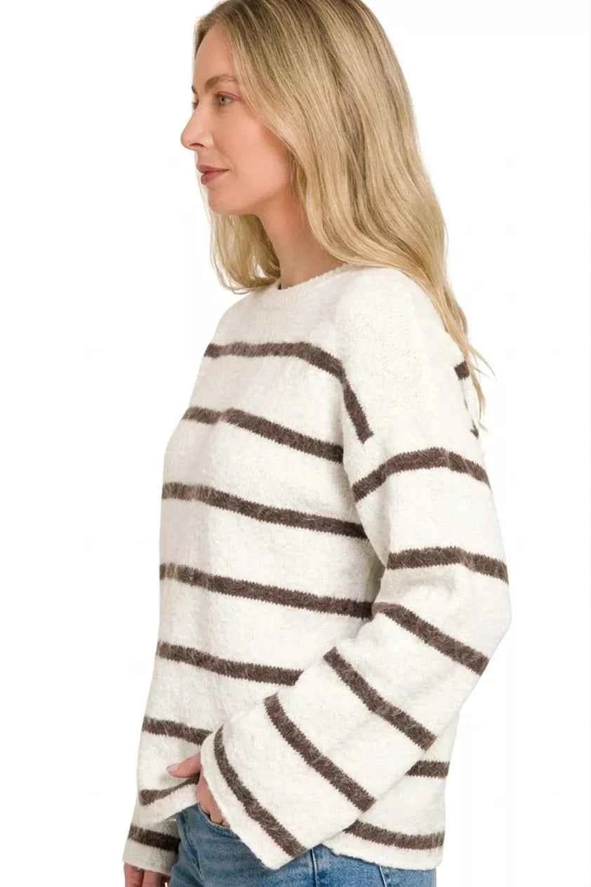 Woman wearing a cream sweater with brown horizontal stripes, long sleeves, and a relaxed fit by Zenana. Side View