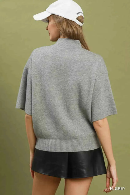 Woman wearing a heather grey mock neck short sleeve knit sweater top by Umgee. Back View