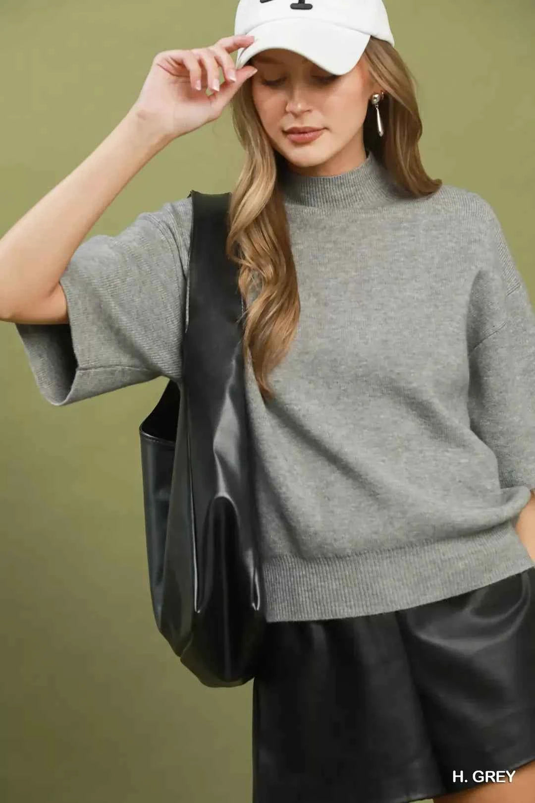 Woman wearing a heather grey mock neck short sleeve knit sweater top by Umgee. Front view