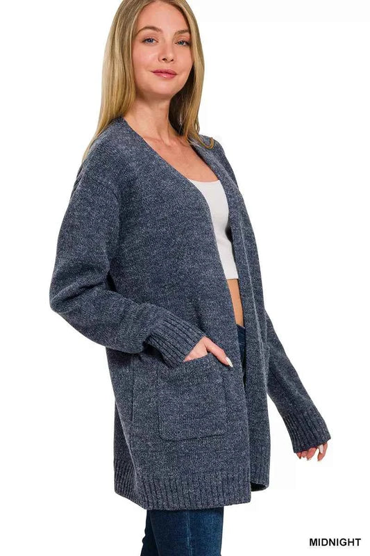 Woman wearing a midnight blue open-front knit cardigan with front pockets over a white tank and dark denim jeans by Zenana. Side View