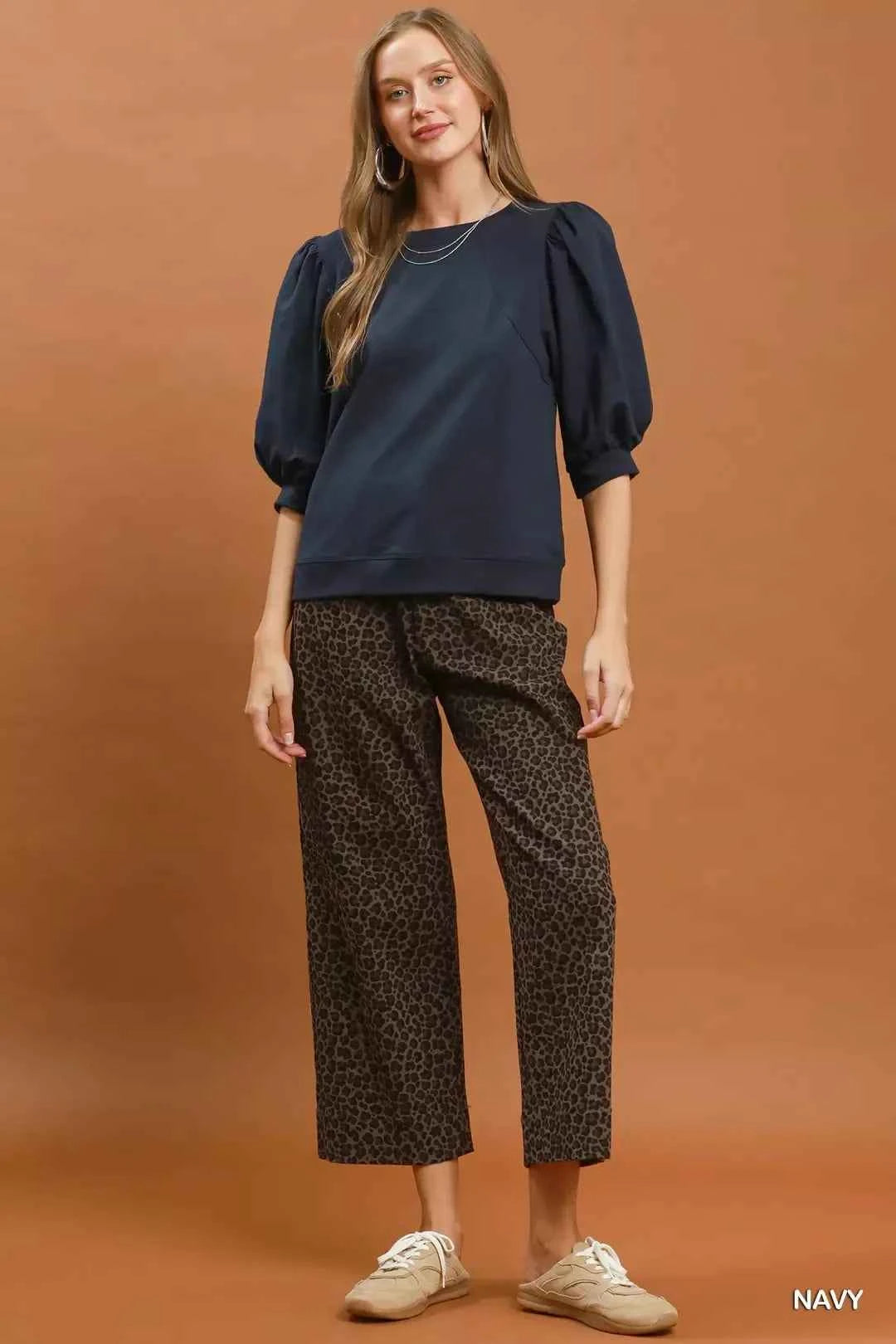 Woman wearing a navy puff sleeve cotton sweatshirt by Umgee paired with leopard print pants for an elevated casual outfit. Full View