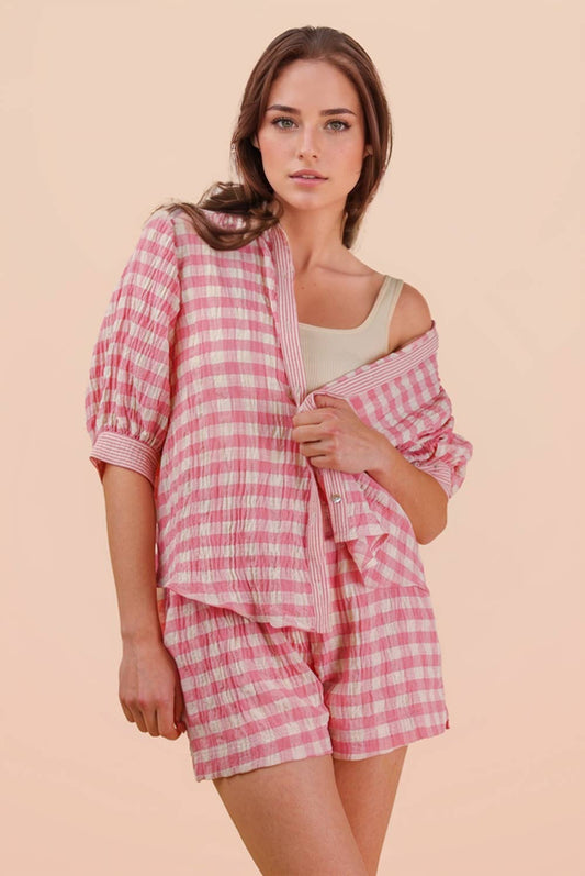 Woman wearing a pink and white gingham button-down shirt and matching drawstring shorts set front view 2