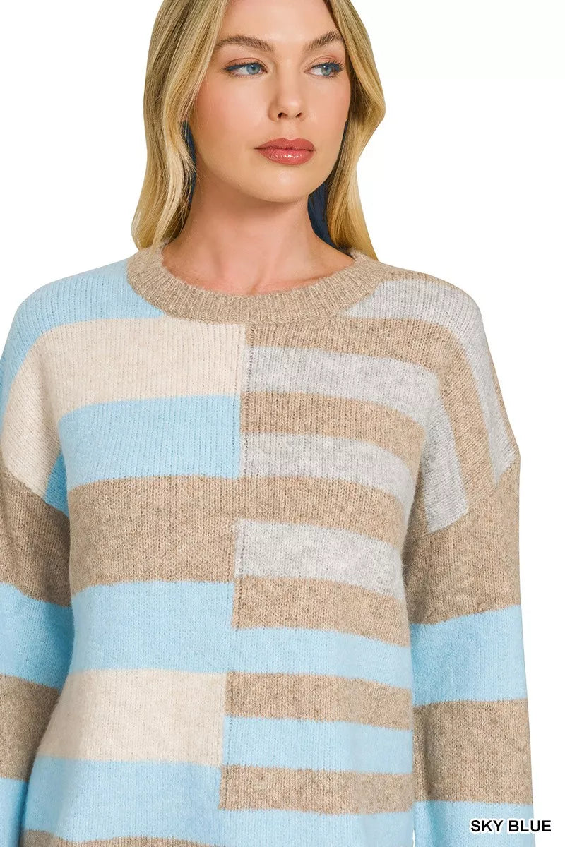 Woman wearing a sky blue, ivory, and oatmeal color block lightweight wool blend sweater by Zenana paired with blue jeans.