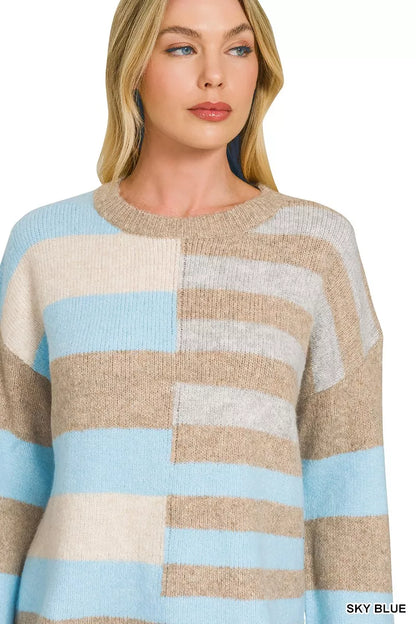 Woman wearing a sky blue, ivory, and oatmeal color block lightweight wool blend sweater by Zenana paired with blue jeans.