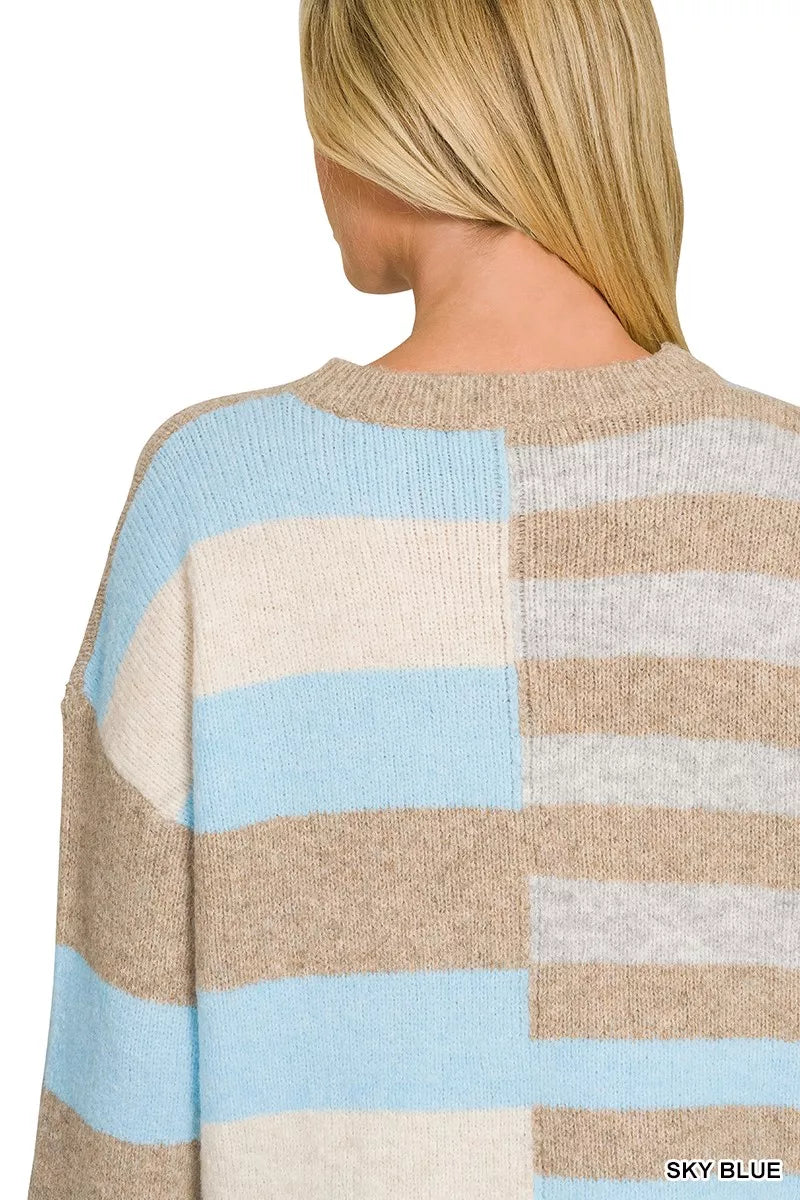 Woman wearing a sky blue, ivory, and oatmeal color block lightweight wool blend sweater by Zenana paired with blue jeans. Back View