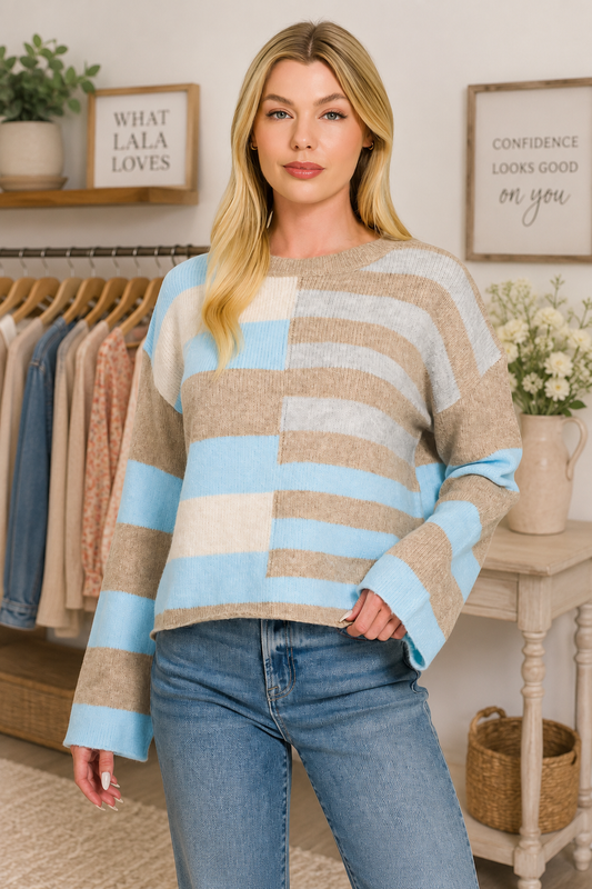 Woman wearing a sky blue, ivory, and oatmeal color block lightweight wool blend sweater by Zenana paired with blue jeans. Front View
