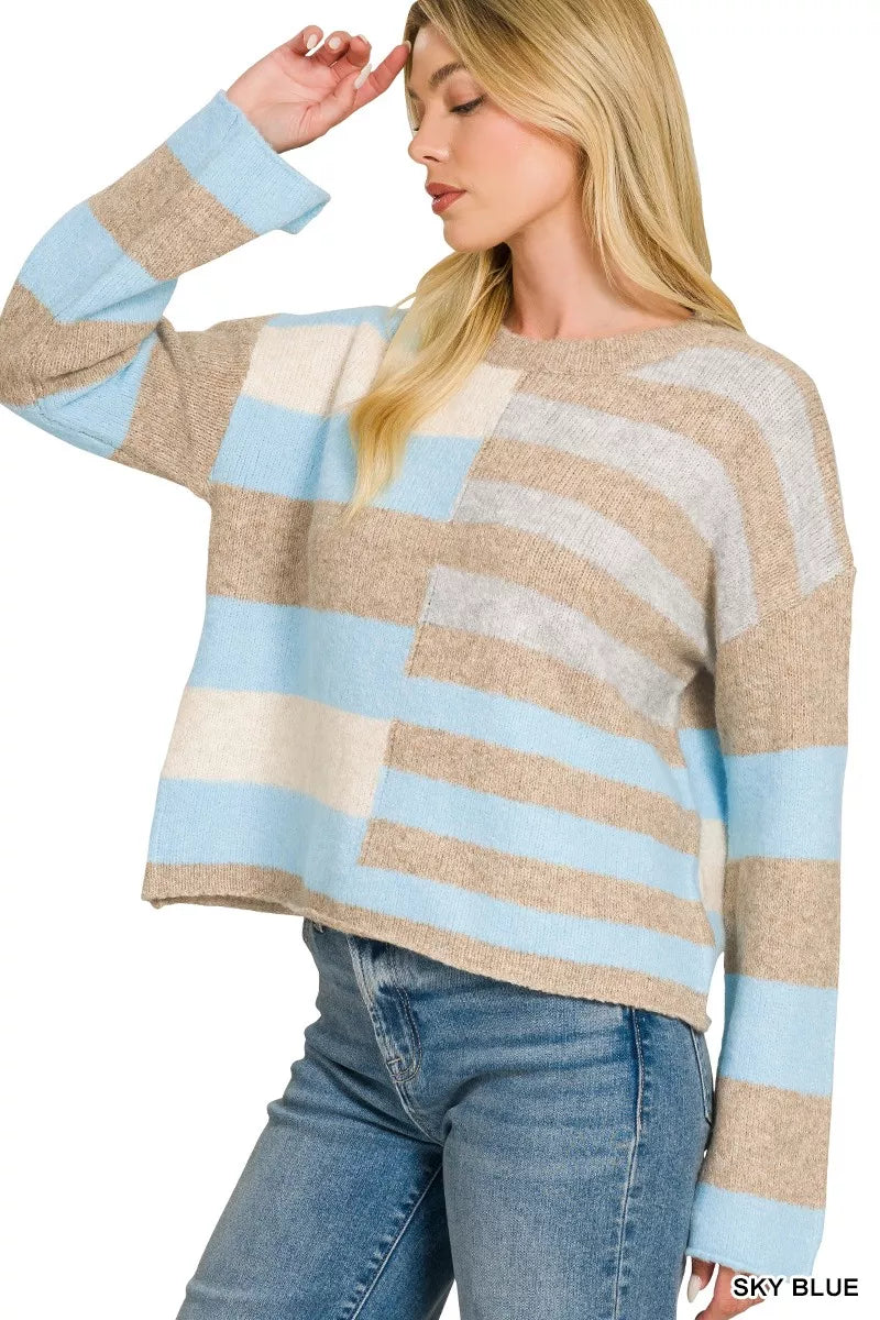 Woman wearing a sky blue, ivory, and oatmeal color block lightweight wool blend sweater by Zenana paired with blue jeans. Front View 3
