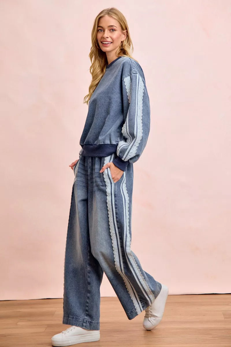 Woman wearing a washed denim lace contrast sweatshirt with long sleeves and relaxed fit by BiBi. Full view 2