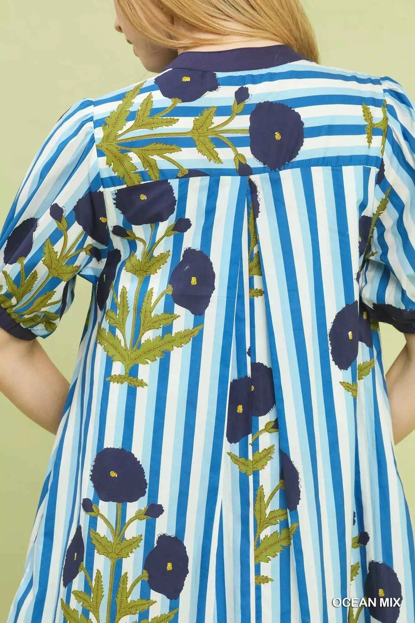 Woman wearing an Ocean Blue mixed floral and stripe print cotton dress with a split V-neckline and contrast trim by Umgee. Close View