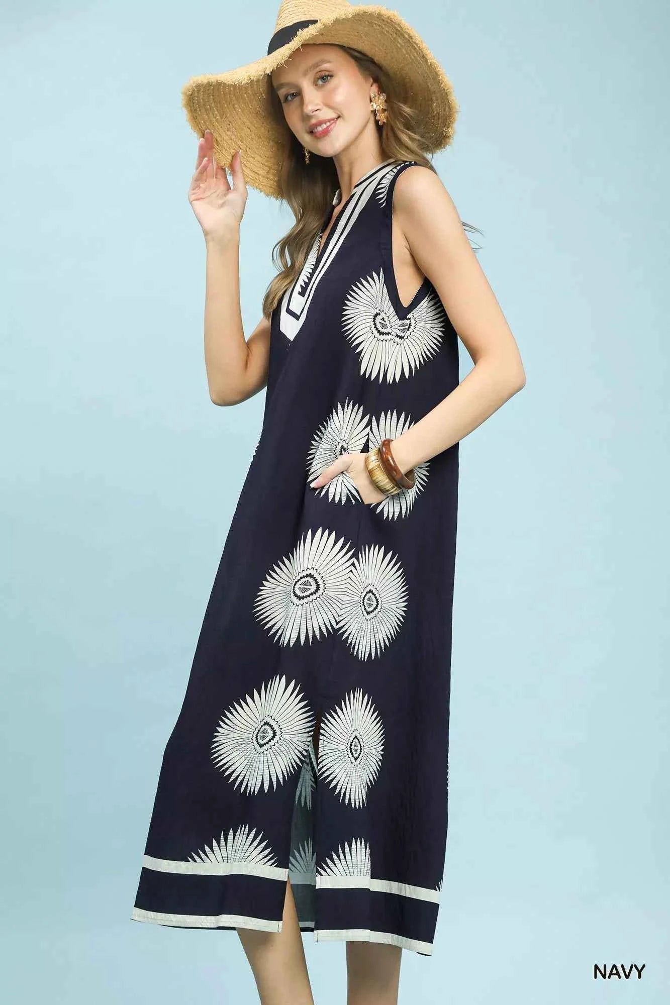 Woman wearing an Ocean Blue mixed floral and stripe print cotton dress with a split V-neckline and contrast trim by Umgee. Side View