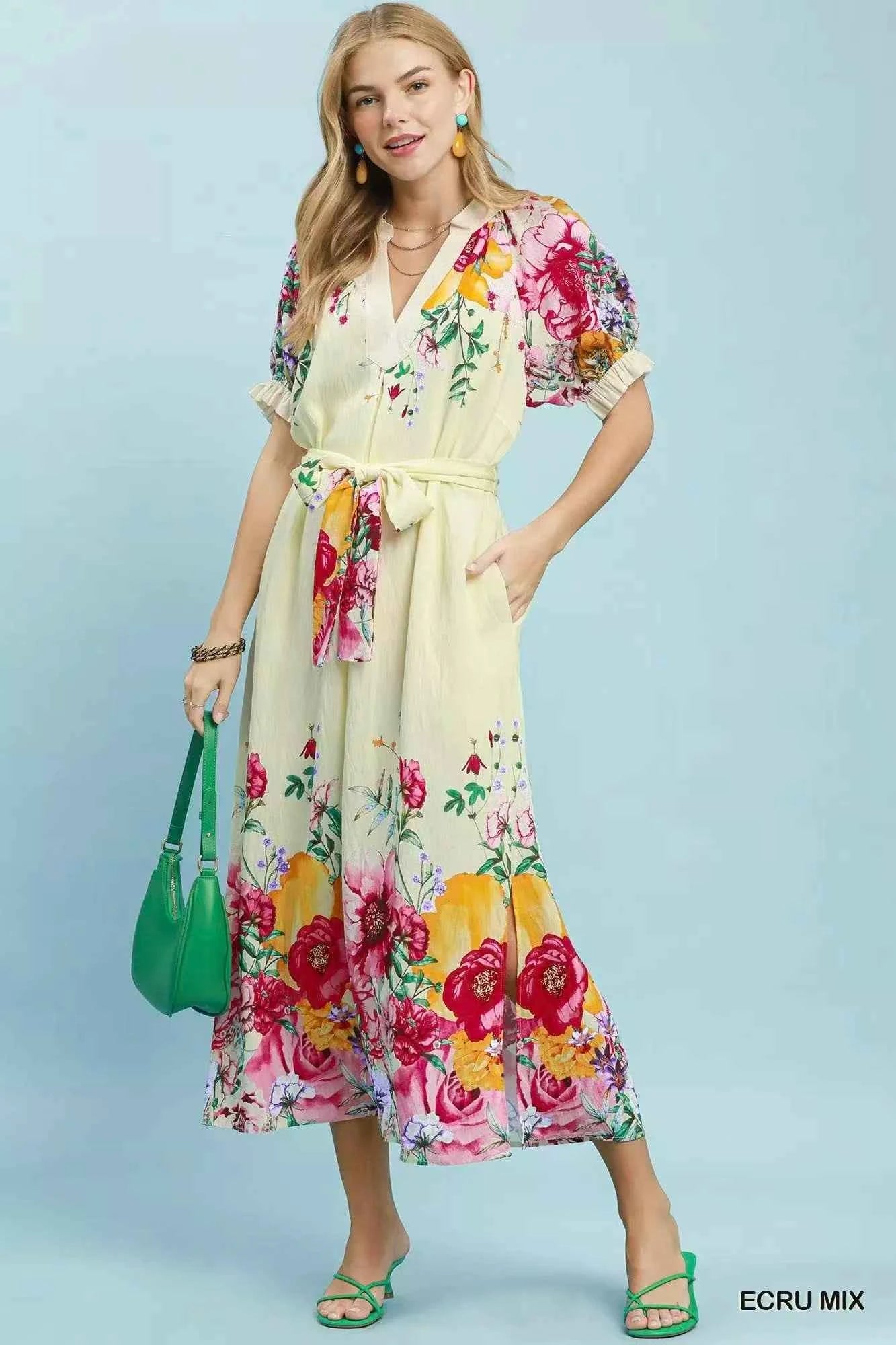Woman wearing an Umgee ecru floral border print midi dress with a waist tie, puff sleeves, and colorful floral details. Front View 2