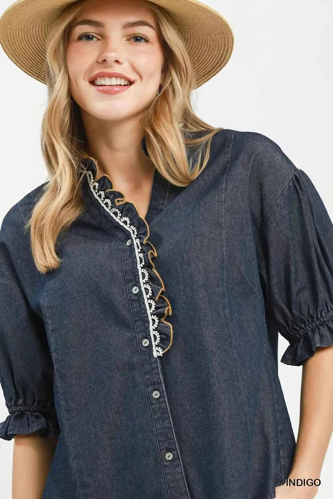 Woman wearing an Umgee indigo chambray button front blouse with lace trim neckline and puff sleeves styled with casual shorts. Close View