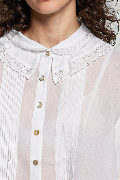 Woman wearing an ivory lace trim pintuck button-down blouse from POL, featuring romantic lace details, pleated front accents, and a relaxed fit. close view 2
