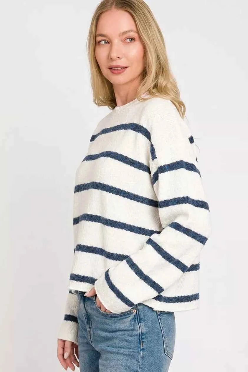 Woman wearing an ivory lightweight wool blend sweater with navy stripes by Zenana paired with blue jeans. Side View 2