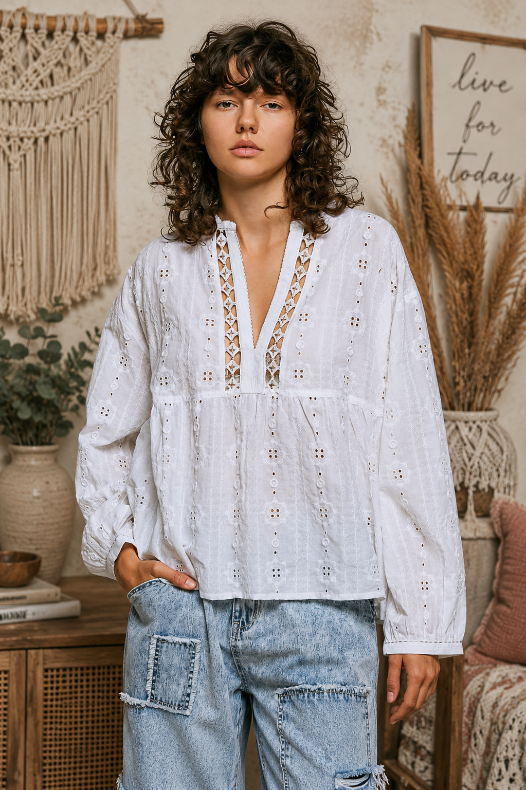 Woman wearing an off white POL cotton blouse with eyelet embroidery, lace detailing, and a split neckline.
 Front view