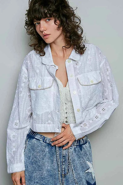 Woman wearing an off white eyelet textured cotton cropped button-front jacket by POL with relaxed denim jeans. front view 2