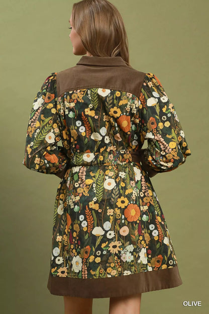 Woman wearing an olive floral print mini dress by Umgee featuring a collared neckline, puff sleeves, button-front detail, and a removable tie waist belt. back view
