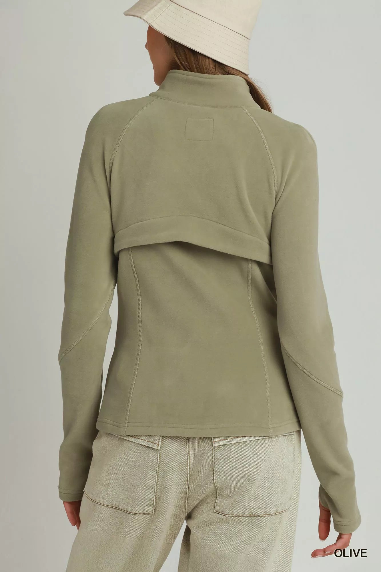 Woman wearing an olive soft fleece full zip jacket with side pockets by Umgee. Back View