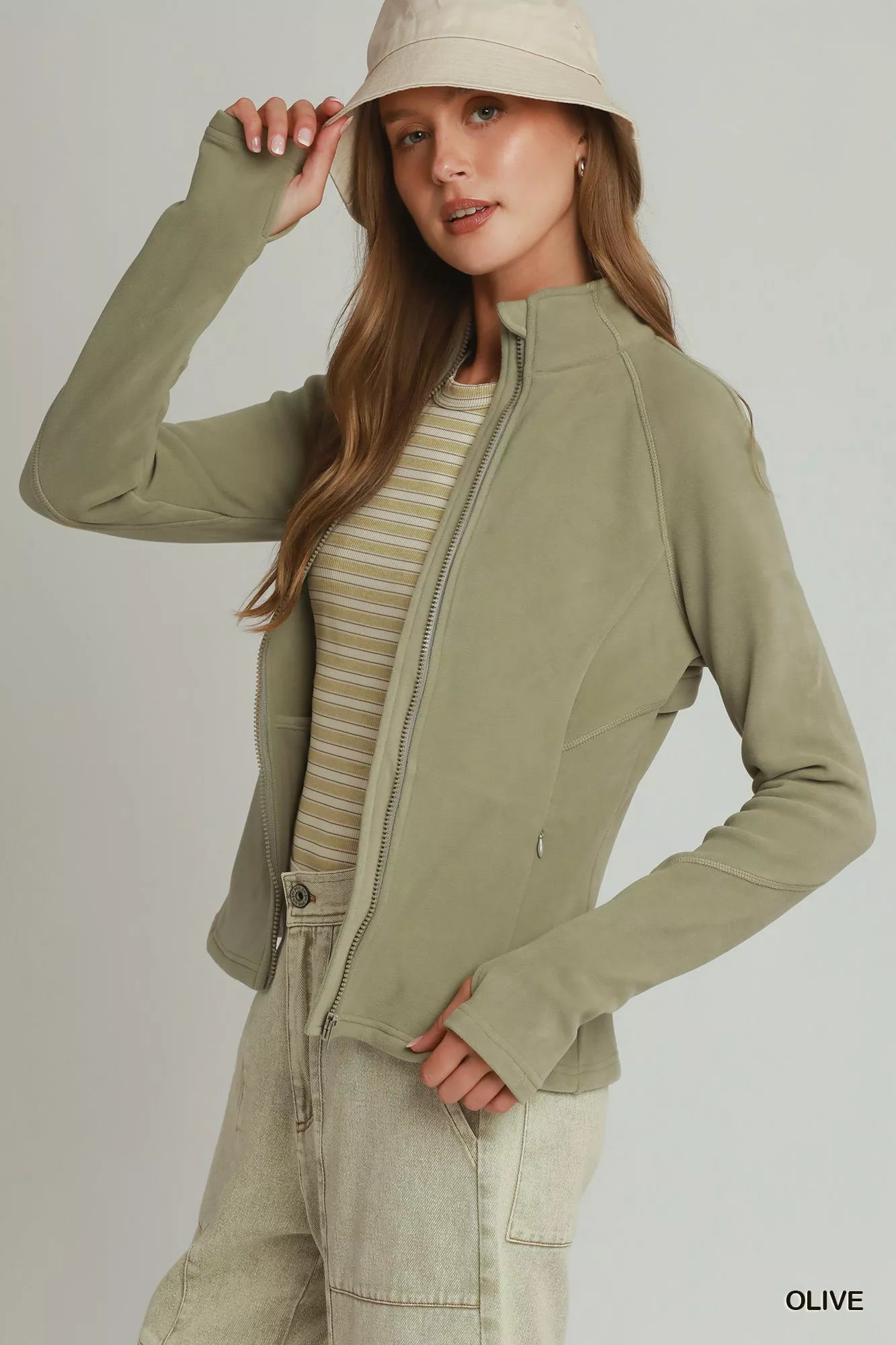 Woman wearing an olive soft fleece full zip jacket with side pockets by Umgee. Side View