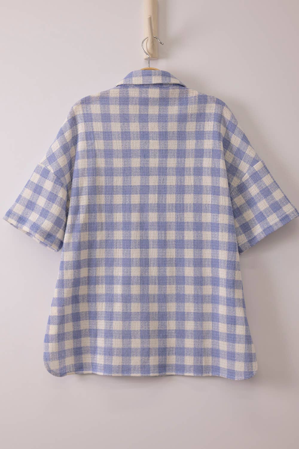 Woman wearing an oversized checkered button-down woven shirt with patch pockets and short sleeves front view from VERY J in blue back view