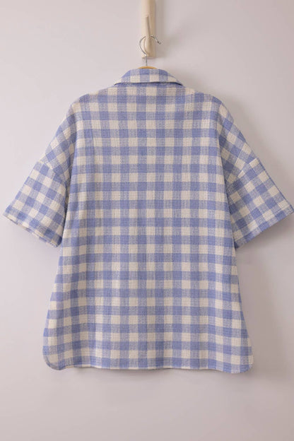 Woman wearing an oversized checkered button-down woven shirt with patch pockets and short sleeves front view from VERY J in blue back view