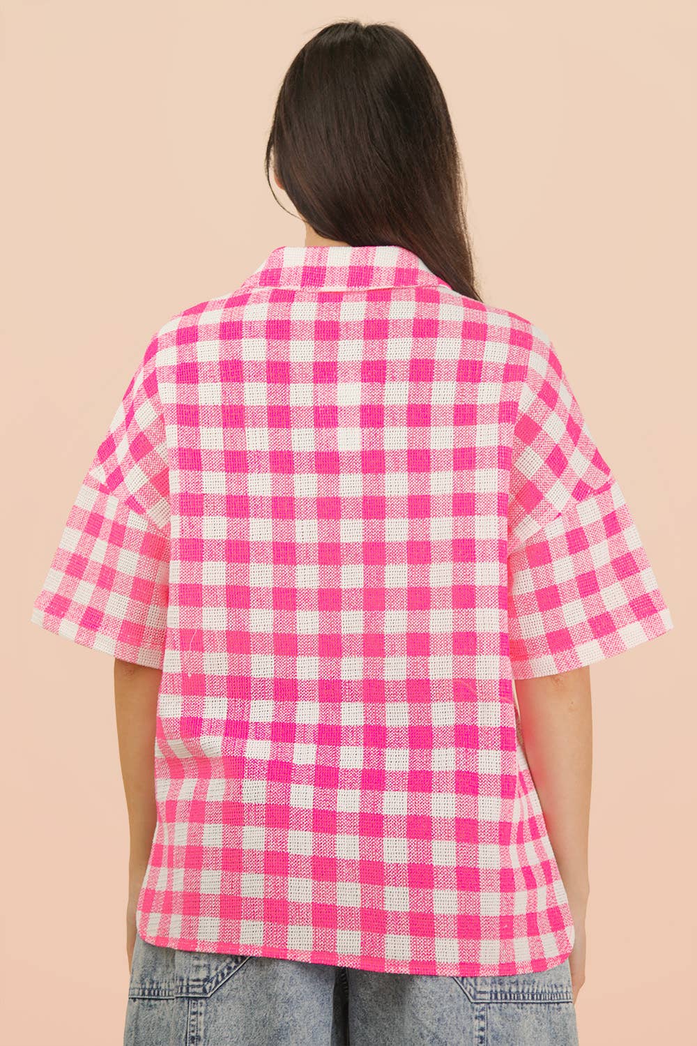 Woman wearing an oversized checkered button-down woven shirt with patch pockets and short sleeves front view from VERY J in pink back view