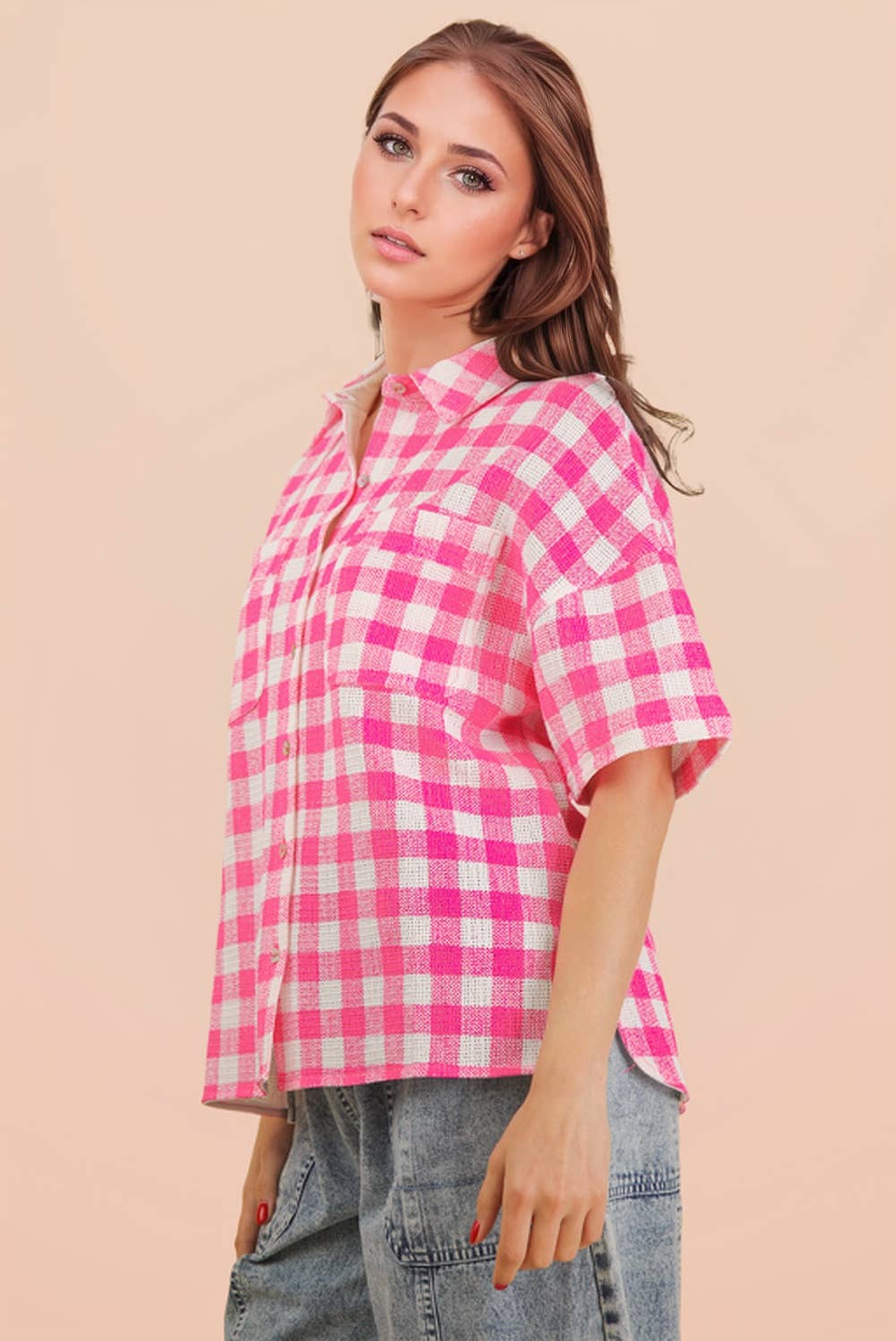Woman wearing an oversized checkered button-down woven shirt with patch pockets and short sleeves front view from VERY J in pink side view
