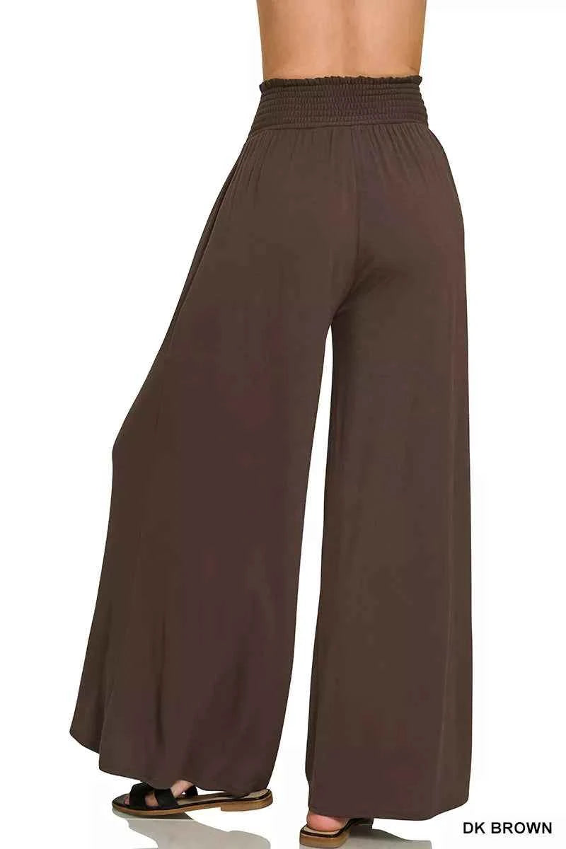 Woman wearing dark brown Zenana smocked waist wide leg palazzo pants with pockets and a flowy relaxed fit.
 Back View