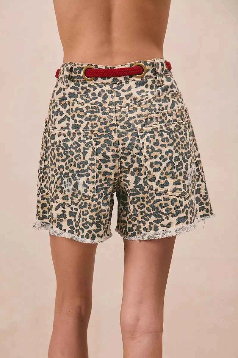 Woman wearing leopard print cotton shorts with a braided tassel waist belt, raw hem, and oversized front patch pockets by BiBi. Back View