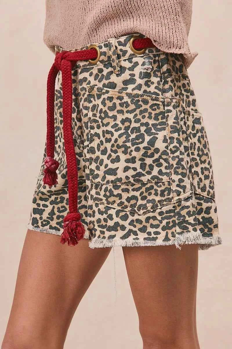 Woman wearing leopard print cotton shorts with a braided tassel waist belt, raw hem, and oversized front patch pockets by BiBi. Side View