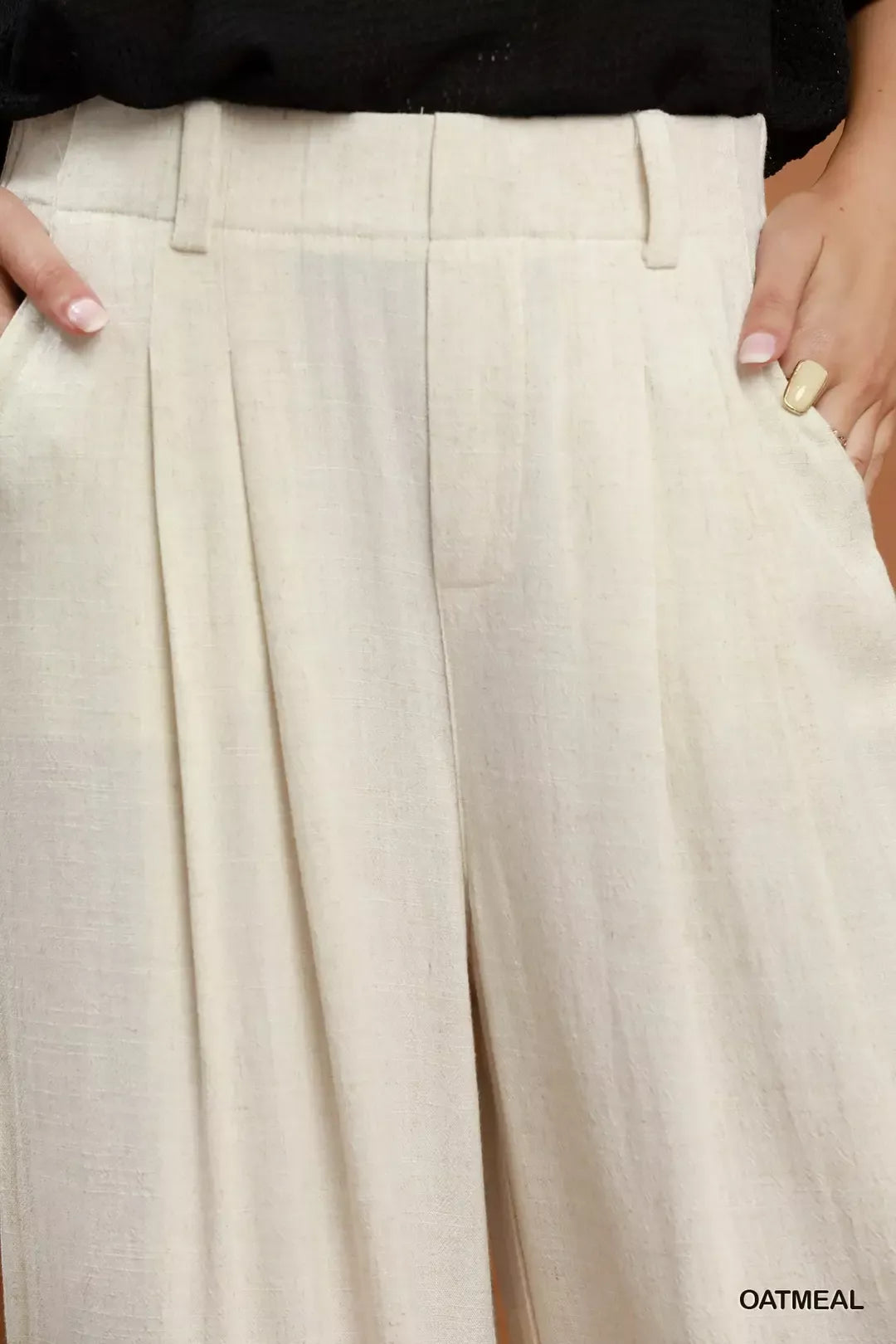 Woman wearing oatmeal high-waisted linen blend wide leg trousers with pleated front and pockets by Umgee. Close View
