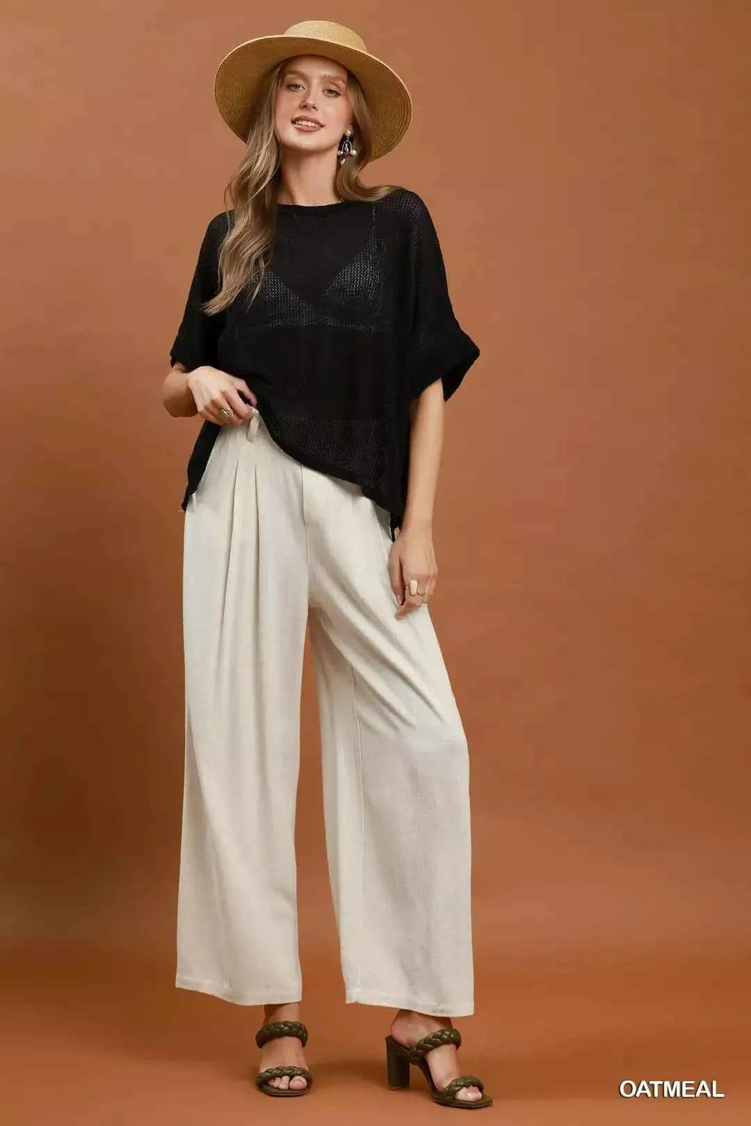 Woman wearing oatmeal high-waisted linen blend wide leg trousers with pleated front and pockets by Umgee. Full View