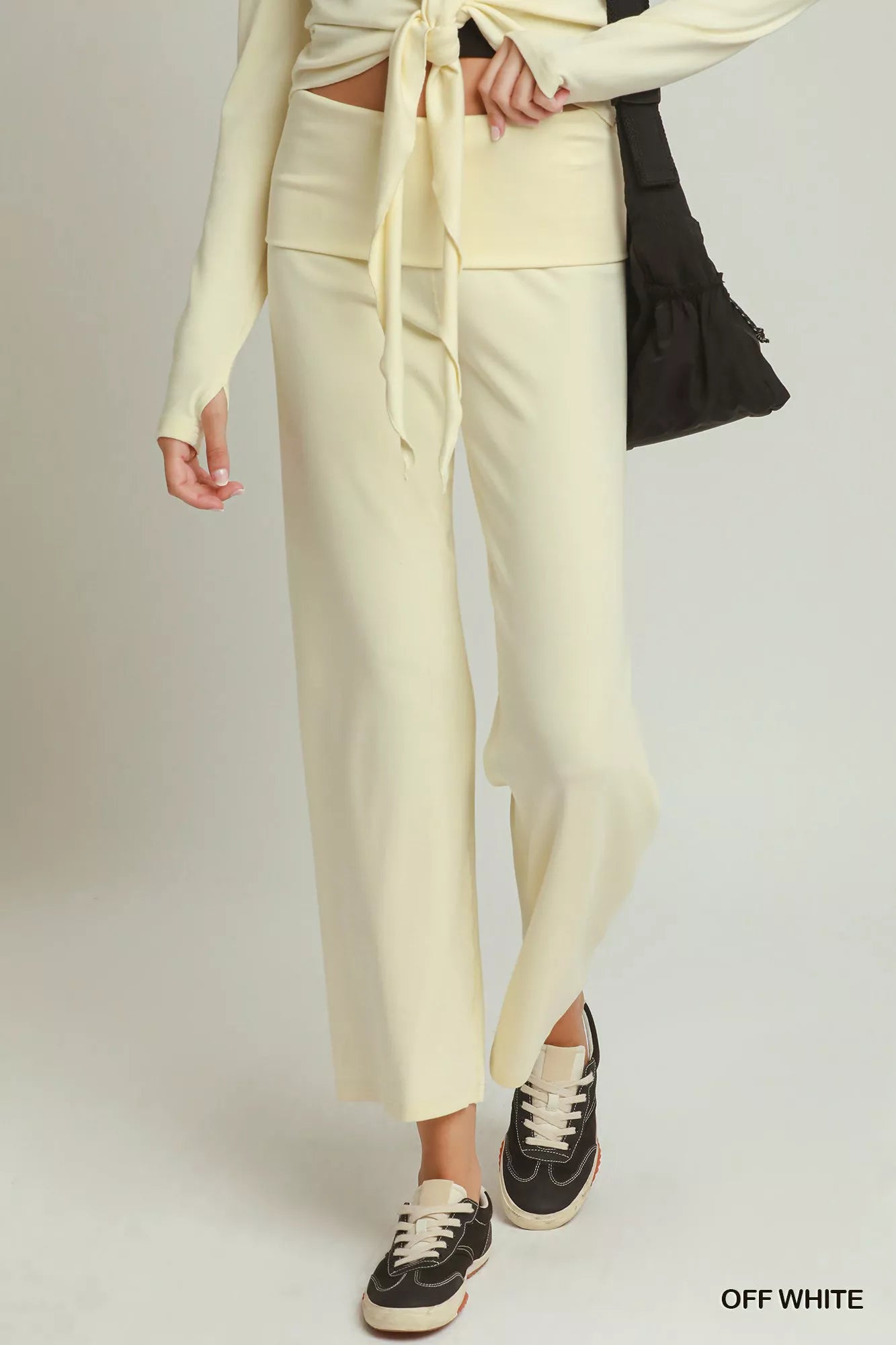 Woman wearing off white straight-leg pants by Umgee styled with black sneakers and a coordinating knit top. Front View