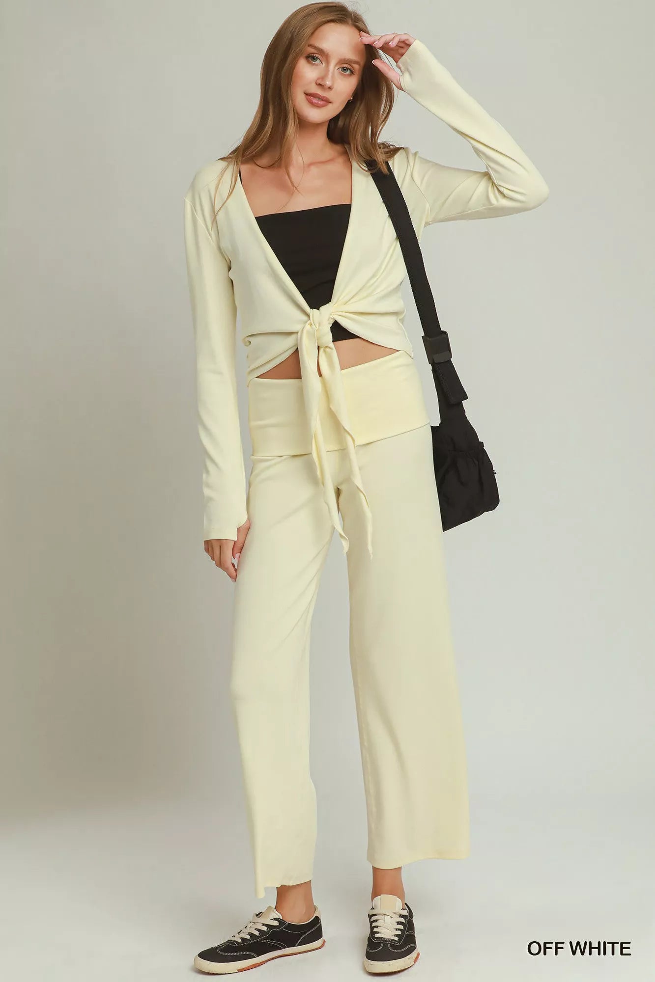 Woman wearing off white straight-leg pants by Umgee styled with black sneakers and a coordinating knit top. full View