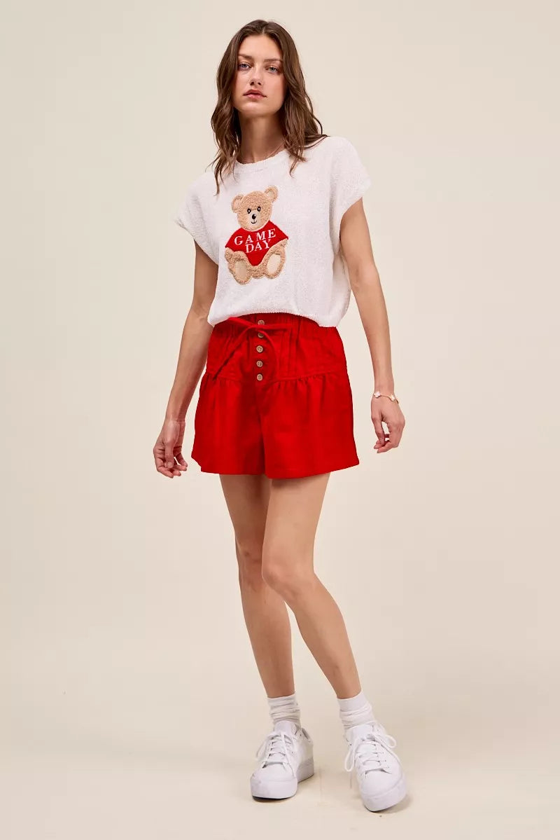 Woman wearing red high waist shorts with pintuck detailing, button-front accents, elastic waistband, and adjustable waist tie. Full View 3