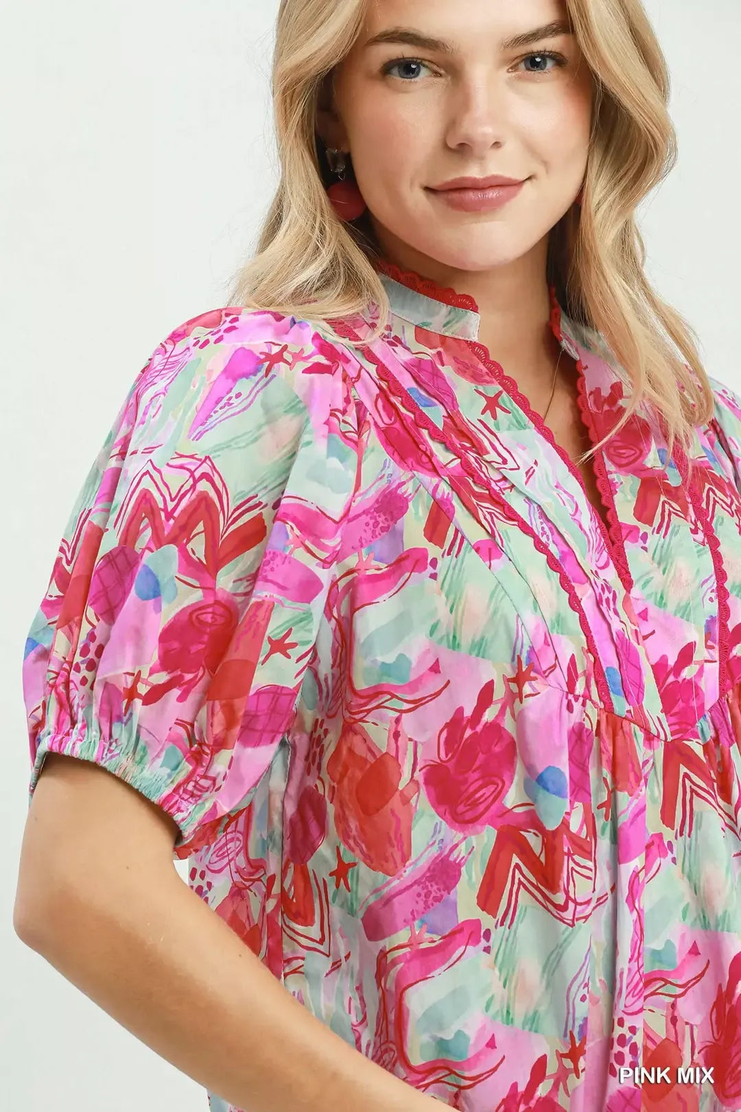 Women's Umgee pink mix abstract print blouse featuring colorful artistic patterns, puff sleeves, ruched details, and a relaxed cotton silhouette. Close view