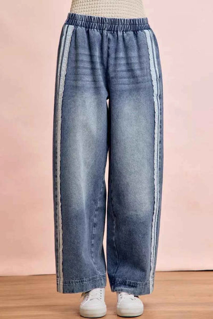 Women's washed denim jeans with lace side panel detailing, relaxed fit silhouette, and vintage-inspired finish by BiBi. Front view