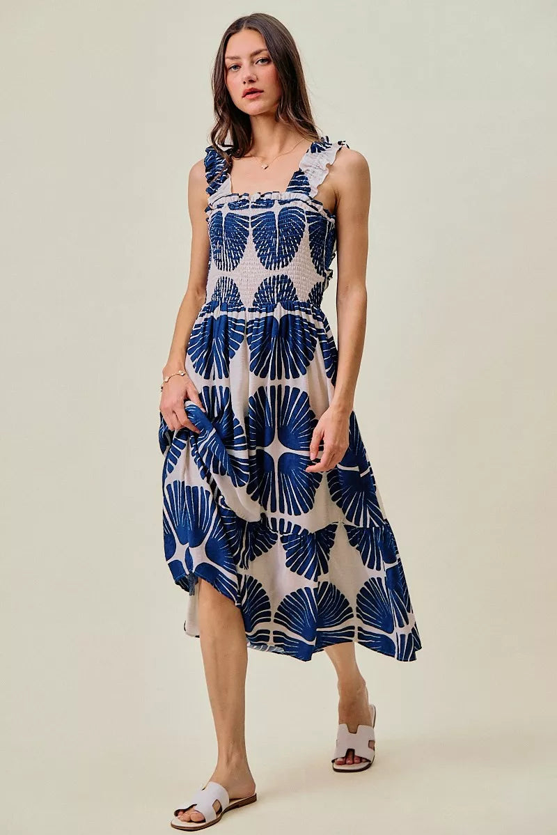 Woman wearing SO ME navy abstract print smocked bodice tiered midi dress featuring ruffle straps, a flowy tiered skirt, and a flattering feminine silhouette.