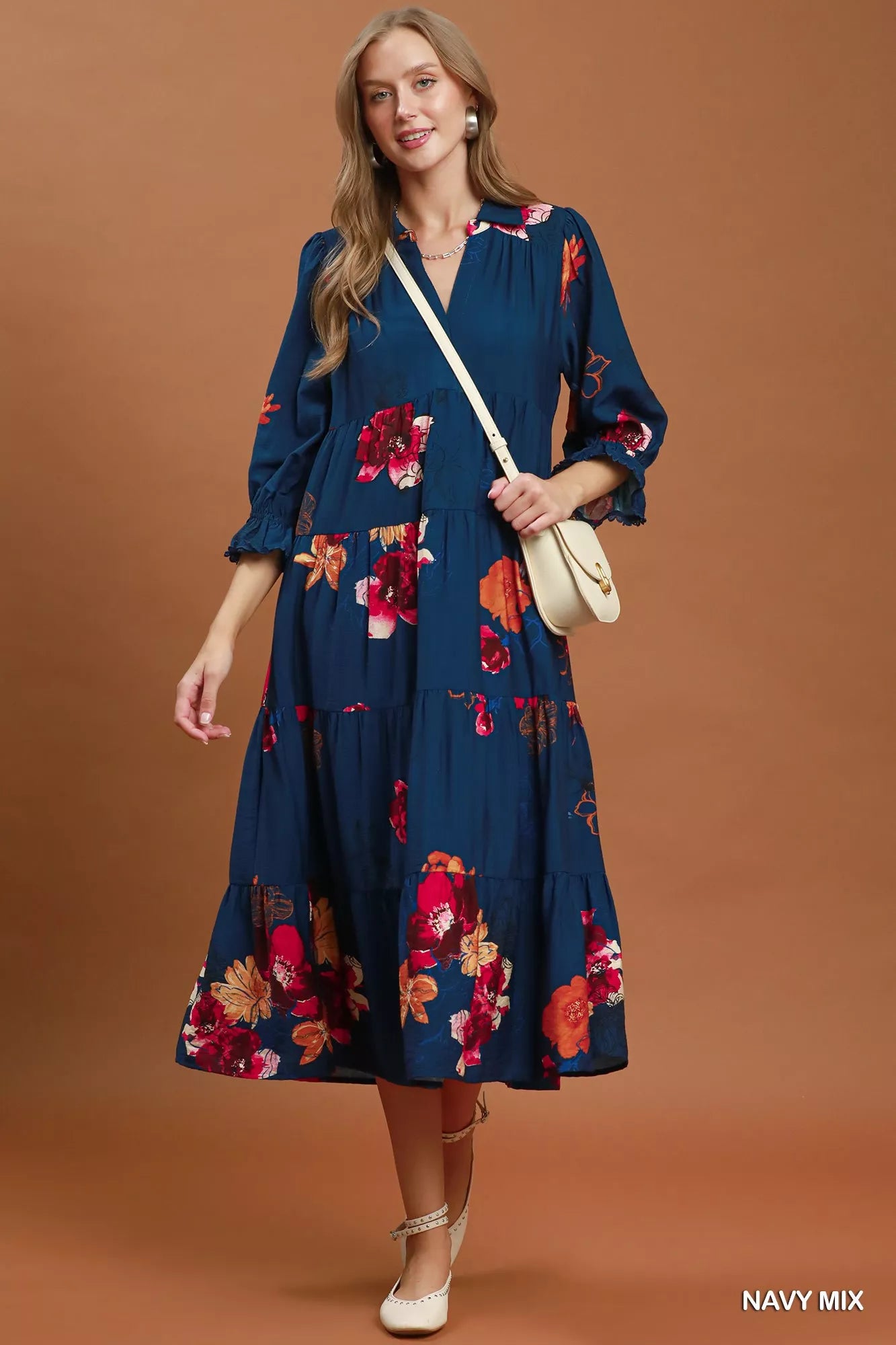 Woman wearing an Umgee navy floral tiered midi dress with puff sleeves, pockets, and a flowy feminine silhouette.